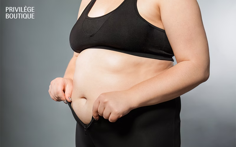 Person adjusting waistband, focusing on midsection.